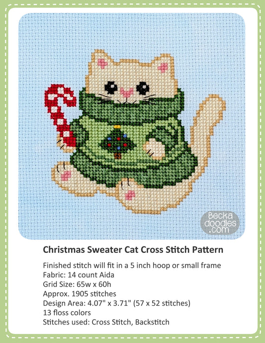 Cross stitch pattern cover for "Christmas Sweater Cat", showing a completed stitched design of a cream-colored cat wearing a green sweater and holding a red-and-white candy cane on a light blue fabric, with text below detailing the pattern specifications.