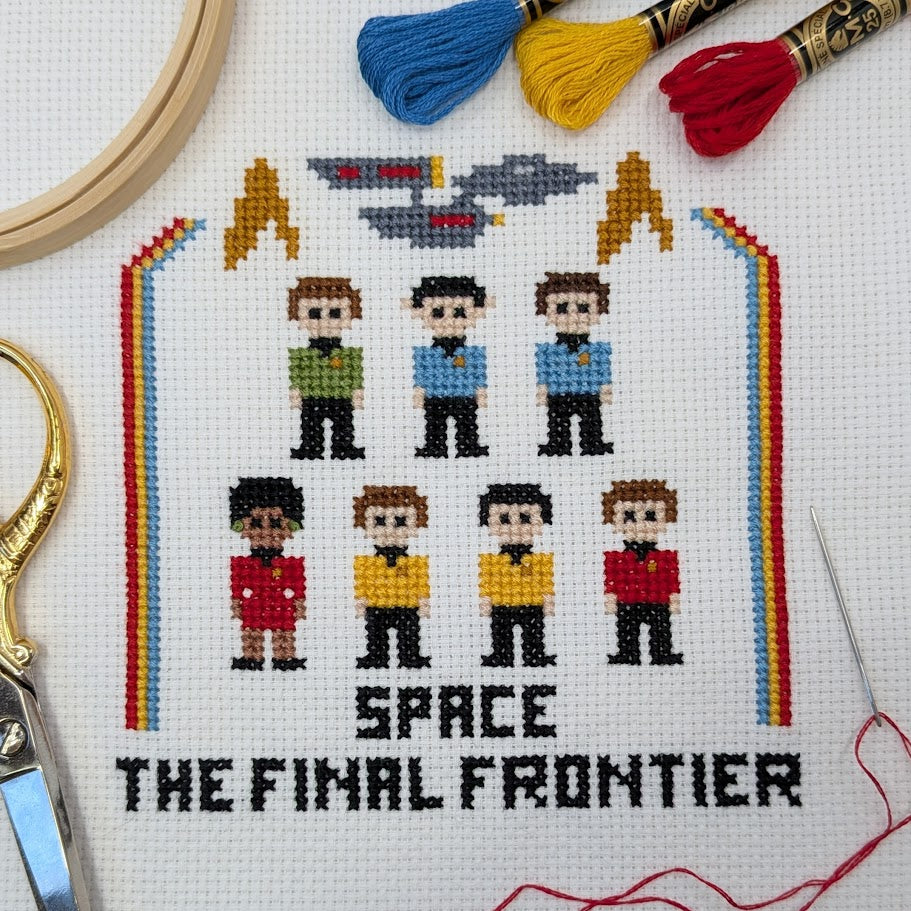 Cross-stitched design of characters from a science fiction show with 'Space: The Final Frontier' text, surrounded by embroidery tools.