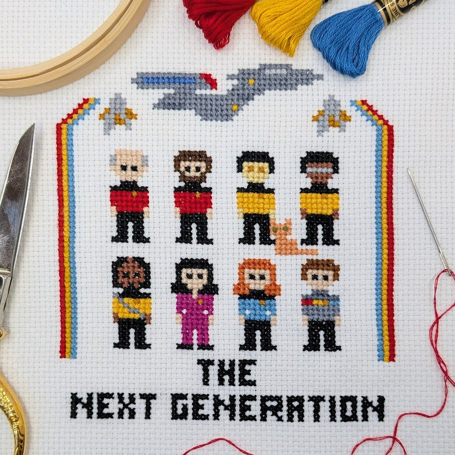 Cross-stitched design of characters from a science fiction series with 'The Next Generation' text, surrounded by embroidery tools.