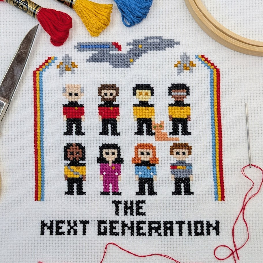 Cross-stitched design of characters from science fiction series with 'The Next Generation' text, surrounded by embroidery tools.