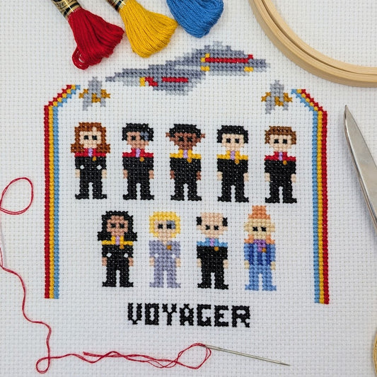 Cross-stitched design of characters from science fiction series with rainbow border on white fabric.