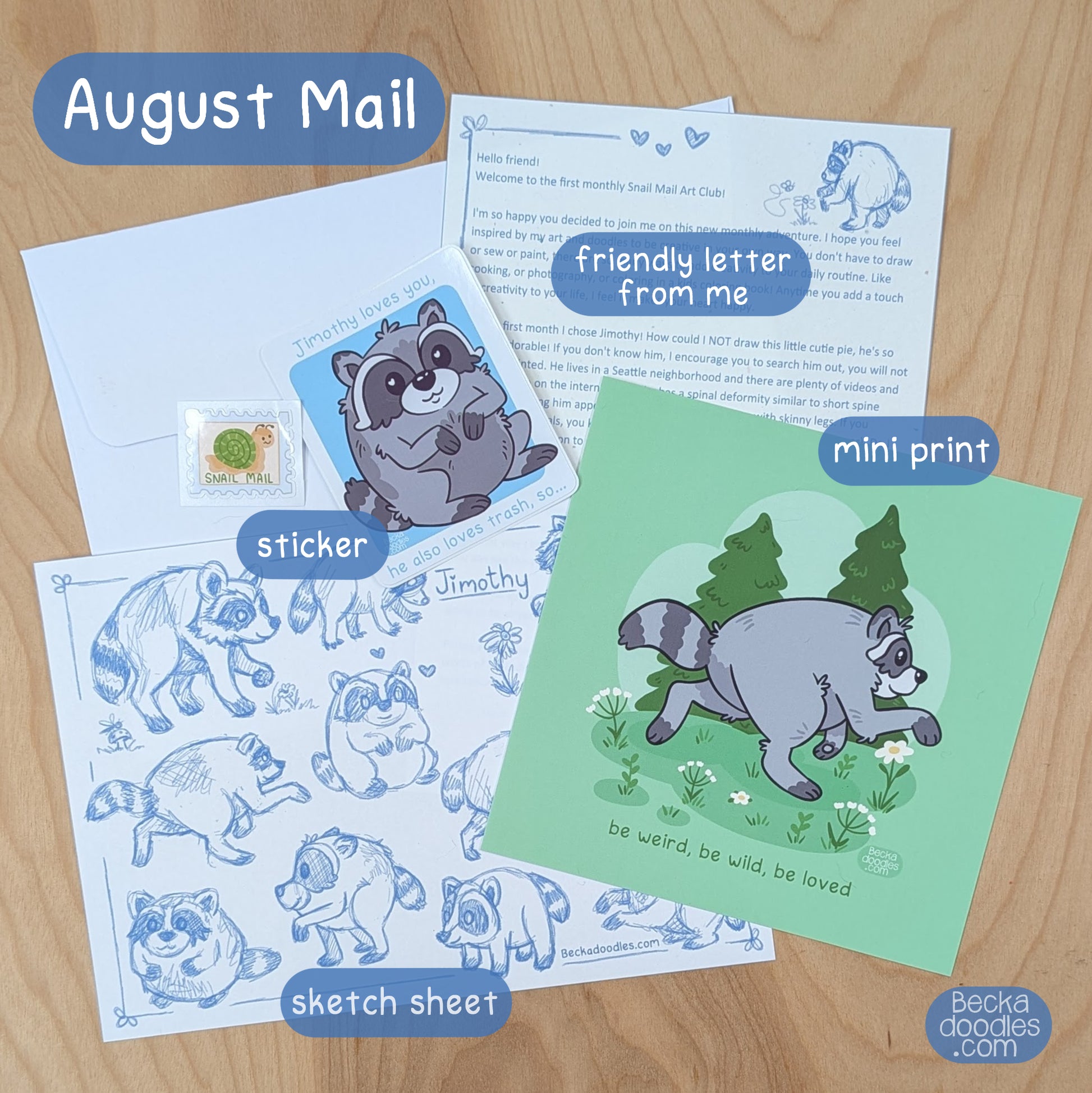 August Snail Mail club set from BeckaDoodles, featuring a raccoon-themed letter, mini print, sticker, and sketch sheet arranged on a light wood background.
