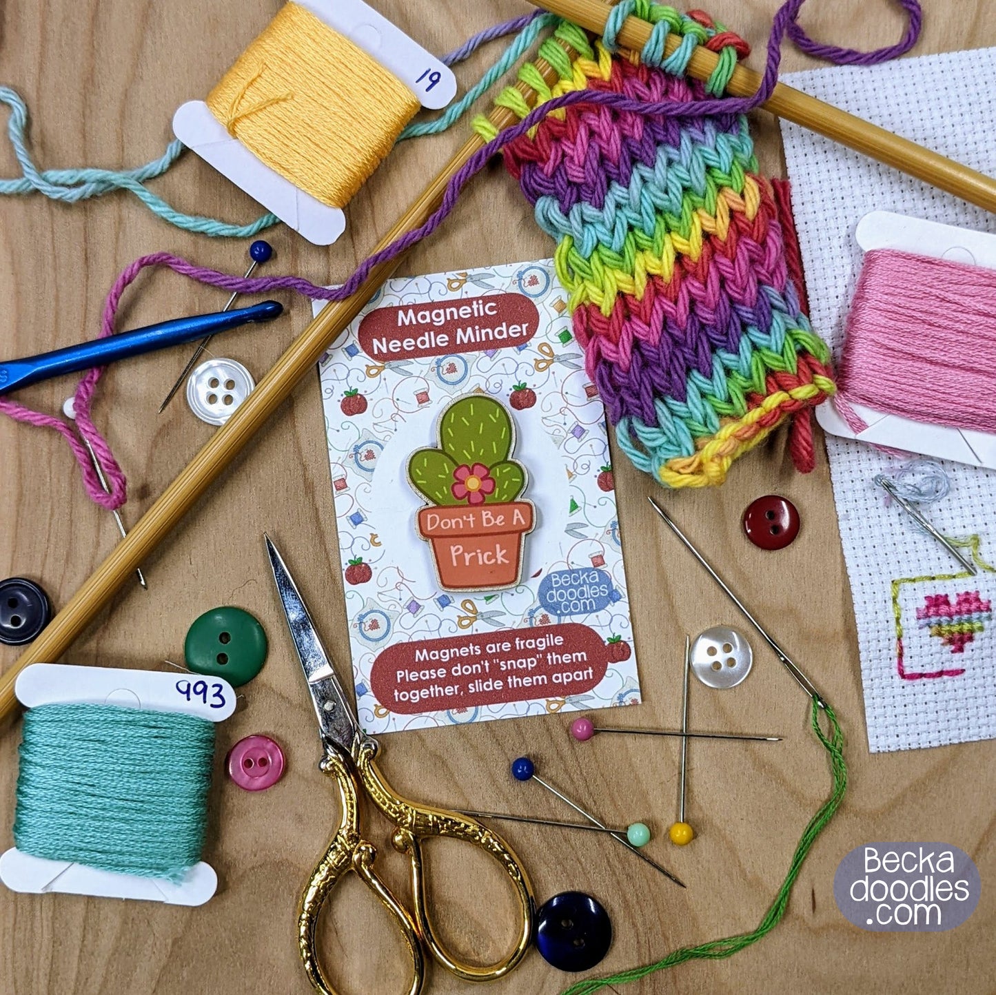Knitting and crochet supplies including yarn, needles, and a colorful knitted swatch on a wooden surface.