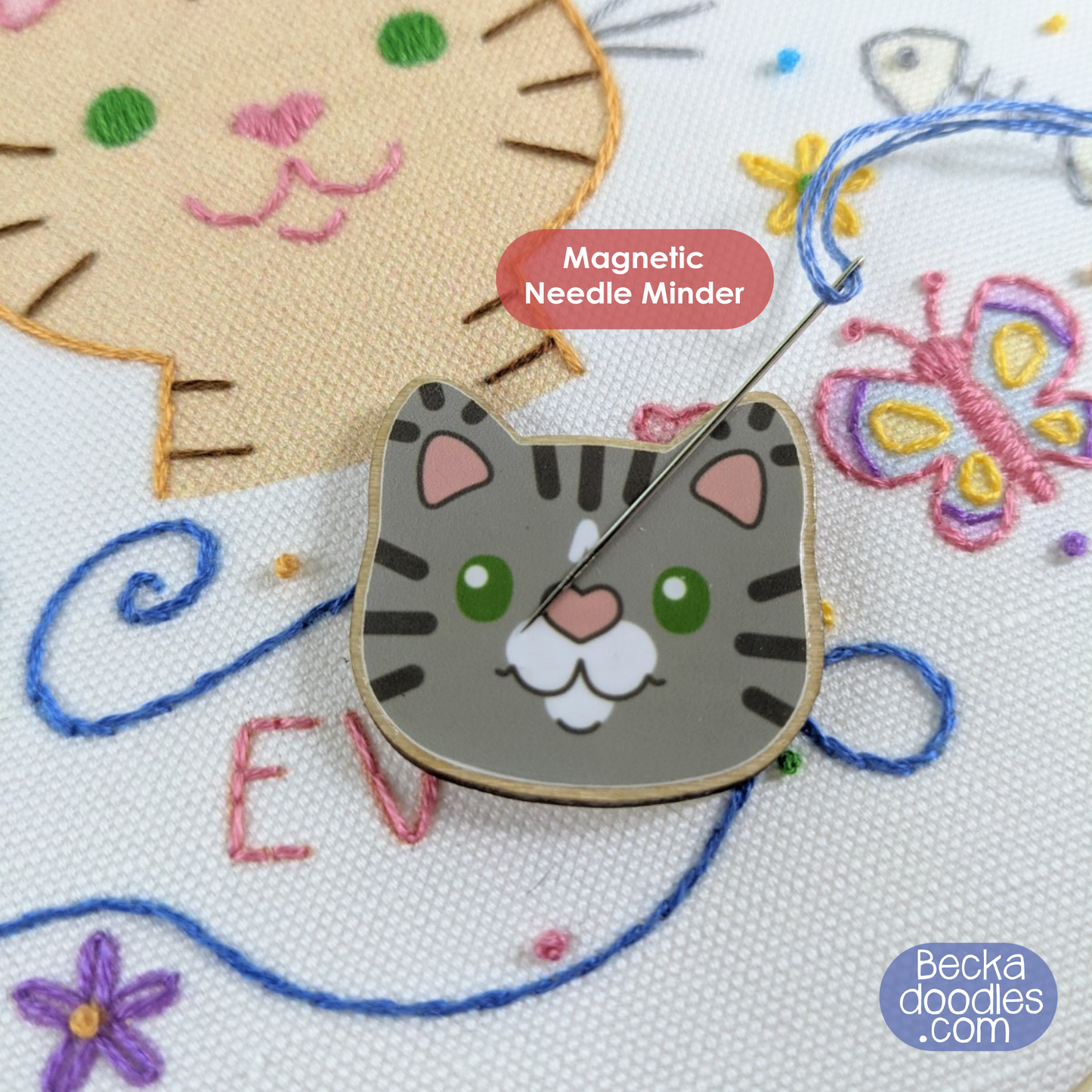 Cat-shaped magnetic needle minder on embroidery with colorful designs